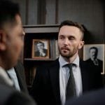 Group of men in suits having a serious business discussion in a professional setting.