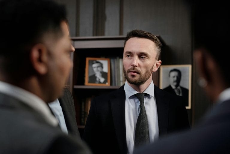 Group of men in suits having a serious business discussion in a professional setting.